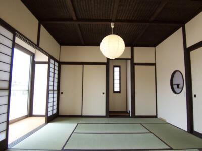 丸窓と丸い和紙の照明と床の間がある和室
