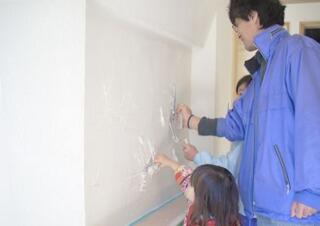 漆喰塗りにご家族で参加するお客様の写真